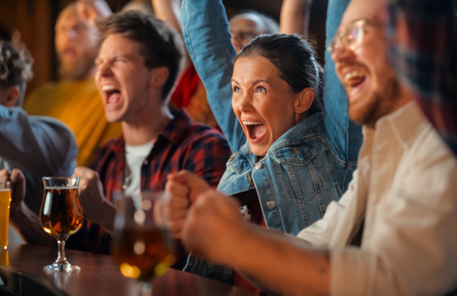 A group of people sitting at a table with beers.