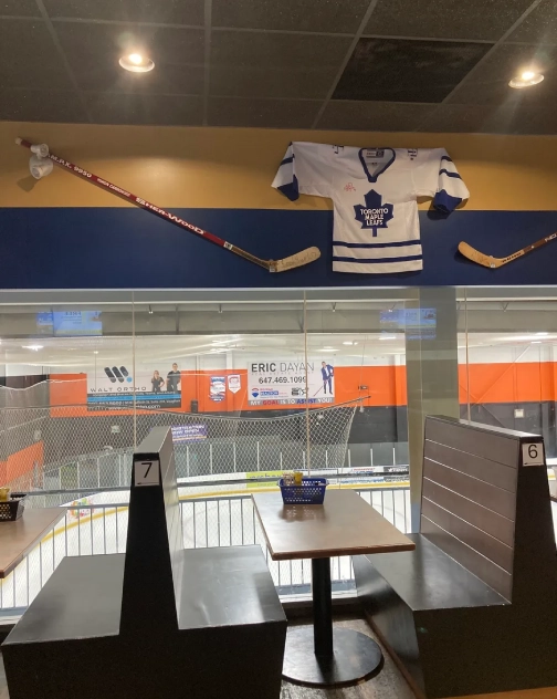 A hockey jersey hangs on the wall above tables.